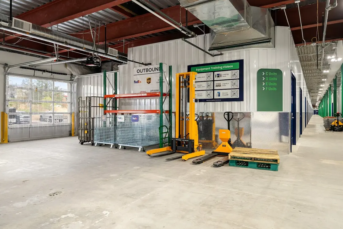 Shared WareSpace loading and equipment area with pallet jacks and outbound carrier bins